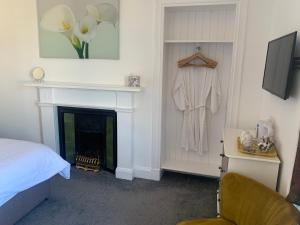 a bedroom with a fireplace and a bed and a chair at Kinnoch Lodge in Dalneigh