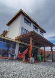 un cane in piedi di fronte a una casa di QUINTAS DA BARRA BNB a 30m da praia a Balneário Barra do Sul Altre 174 foto