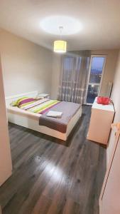 Un dormitorio con una cama grande y una ventana en Елегантен градски апартамент с обширна тераса, en Pernik
