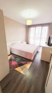 Un dormitorio con una cama grande y una alfombra colorida en Елегантен градски апартамент с обширна тераса, en Pernik