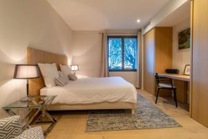 a bedroom with a bed and a desk and a window at Mougins Collection - Magnifique Maison du Vieux Village de Mougins, avec Bassin à débordement et vues Mer et Montagnes in Mougins