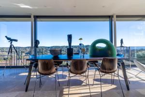 a dining room with a table and chairs and large windows at Mougins Collection - Magnifique Maison du Vieux Village de Mougins, avec Bassin à débordement et vues Mer et Montagnes in Mougins