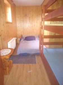 1 dormitorio con 1 cama en una habitación de madera en Agroturystyka Leśna Wyspa, en Kaliska