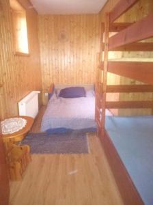 a bedroom with a bed in a wooden room at Agroturystyka Leśna Wyspa in Kaliska