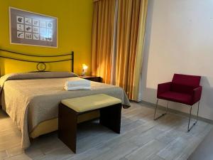 a bedroom with a bed and a red chair at Hotel Le Calandre in Rubano