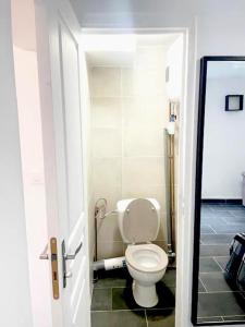 a bathroom with a white toilet in a room at SULLY Studio 20 m2 à 15 minutes de Paris in Drancy