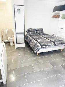 a bedroom with a bed and a tiled floor at SULLY Studio 20 m2 à 15 minutes de Paris in Drancy