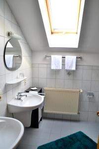 Baño blanco con lavabo y espejo en Pension Anna, en Bodenmais