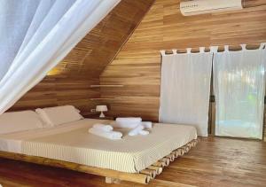 um quarto com uma cama com toalhas em Buena Onda Bungalows em Santa Teresa