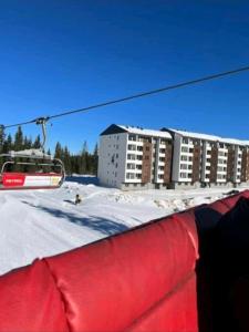 a ski lift in front of a building in the snow at Jahorina Woods - na stazi, ski-to-door in Jahorina