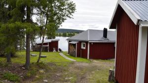 un par de edificios junto a un cuerpo de agua en Lakeside cottage in Lapland with great view en Skaulo