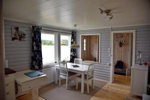 uma sala de jantar com uma mesa e uma secretária em Lakeside cottage in Lapland with great view em Skaulo