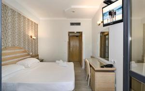 a bedroom with a bed and a tv on a wall at Hotel Nedy in Marina di Massa