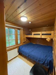 a bedroom with a blue bed in a cabin at Siljonranta in Muonio