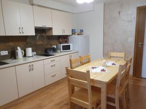 kuchnia z drewnianym stołem i białymi szafkami w obiekcie Mrowca Noclegi Pokoje Gościnne w mieście Gronków
