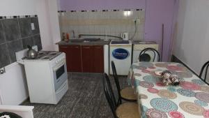 a kitchen with a table and a stove and a stove top oven at Departamento La Argentina in San Luis