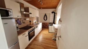cocina con electrodomésticos blancos y suelo de madera en Urlaubsnest, en Harbach