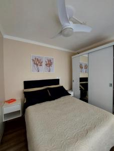 1 dormitorio con 1 cama y ventilador de techo en Apto Confortável próximo ao Consulado Americano, en Porto Alegre