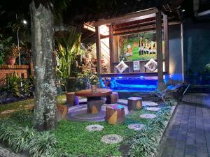 a garden area with a table and a sign at Ngampilan Backpacker Hostel in Yogyakarta