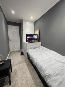 a bedroom with a bed and a flat screen tv at Tilbury Docks Rooms for Short letting in Tilbury