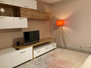 - un salon avec une télévision et une lampe dans l'établissement Olivia`s Studio - apartment Iasi, à Iaşi