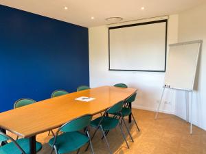 a conference room with a wooden table and chairs at Kyriad Direct Roanne Hôtel in Roanne