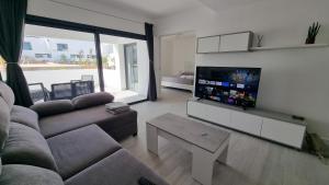 a living room with a couch and a flat screen tv at Casilla de Costa Luxury home in La Oliva
