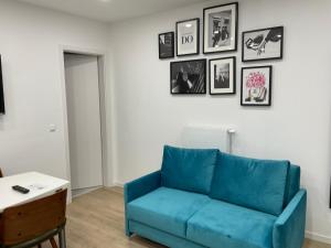 um sofá azul numa sala de estar com fotografias na parede em Deluxe Apartments Messe Flughafen em Leinfelden-Echterdingen