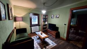 sala de estar con sofá y mesa en Tranquillo ed accogliente appartamento CIR VDA-Valpelline 0003, en Valpelline