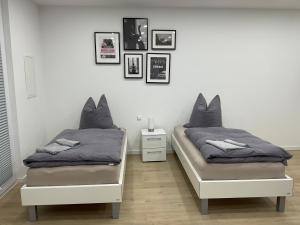 two beds sitting next to each other in a bedroom at Deluxe Apartments Messe Flughafen in Leinfelden-Echterdingen