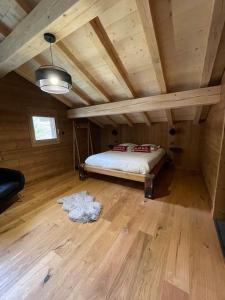 a bedroom with a bed in a wooden room at Chalet Au Chalet de Mel très récent in La Bresse