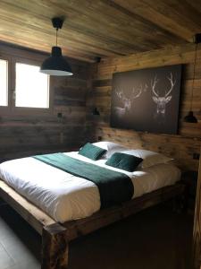a bedroom with a large bed in a cabin at Chalet Au Chalet de Mel très récent in La Bresse