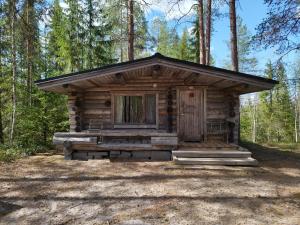 a log cabin in the middle of a forest at Kangasjoki Riverside Camp in Suomussalmi