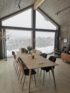 a dining room with a table and a large window at Flott hytte sentralt i Hallingdal in Ål