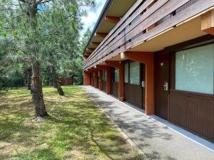 a walkway next to a building with a tree at Kyriad Direct Roanne Hôtel in Roanne