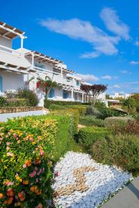 a garden with flowers in front of a building at Perigiali in Skiros +37 photos