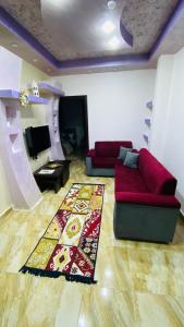 a living room with a red couch and a rug at Petra Rose Apartment in Wadi Musa