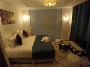 a bedroom with a large bed and a table at Riad Beni Sidel in Marrakech