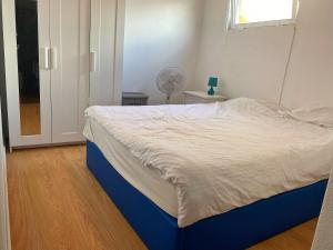1 dormitorio con 1 cama con marco azul y ventana en Relaxing house by the beach - Casa Rosa en Horta