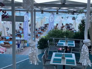 a restaurant with tables and chairs and the ocean at Dream Apartments Saranda in Sarandë
