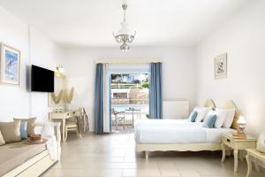 a white bedroom with a bed and a living room at Perigiali in Skiros