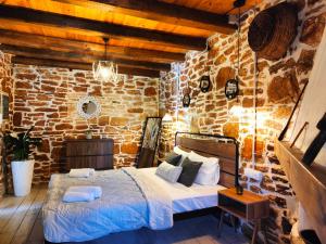 a bedroom with a bed in a brick wall at Vila Apostolis in Agios Pavlos