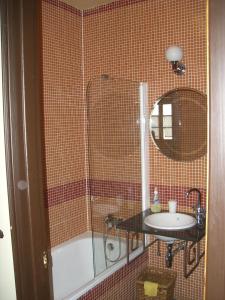 een badkamer met een douche, een wastafel en een bad bij Casa Rural El Saúco in La Vellés