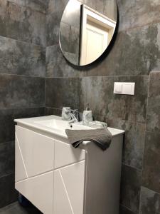 a bathroom with a white sink and a mirror at Однокімнатна квартира in Uman