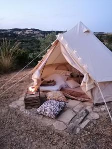 a white tent with pillows and a fire in it at Sa Mola Experience TENDA in Escolca