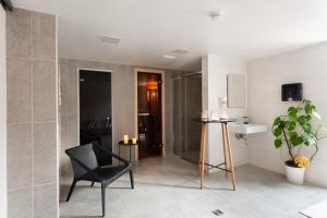 łazienka z czarnym krzesłem i umywalką w obiekcie The View w mieście Honningsvåg