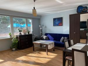 a living room with a blue couch and a table at Apartament Aurelia in Ustka