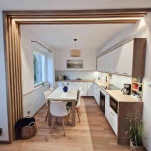 a kitchen with white cabinets and a table and chairs at Barwy Morza in Kopalino