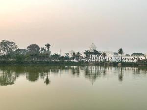 Blick auf ein Gebäude und einen Wasserkörper in der Unterkunft Veda Homestay in Agartala