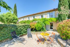 a patio with chairs and a table in front of a building at Mas du PERUSSIER in Cucuron